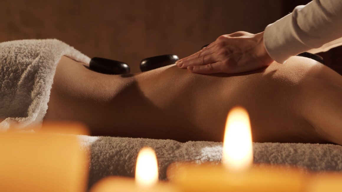 Smooth hot stones placed along a client’s spine