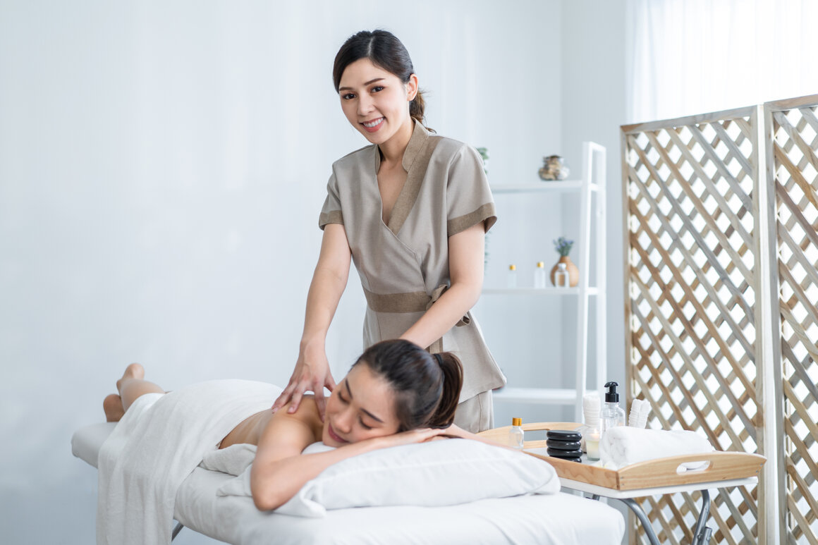 Smiling massage therapist welcoming a client